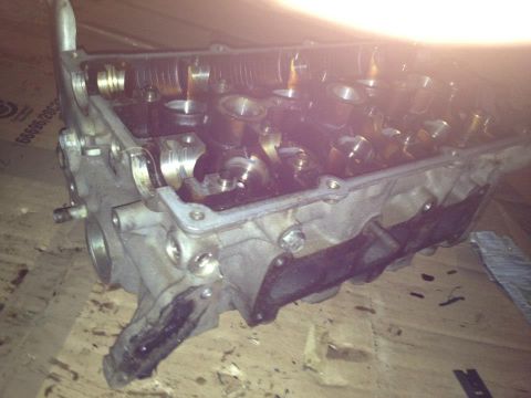 1995 Ford Probe - This is a close-up, angled view of a disassembled engine cylinder head, likely from a 1995 Ford Probe, showing internal components like cam…