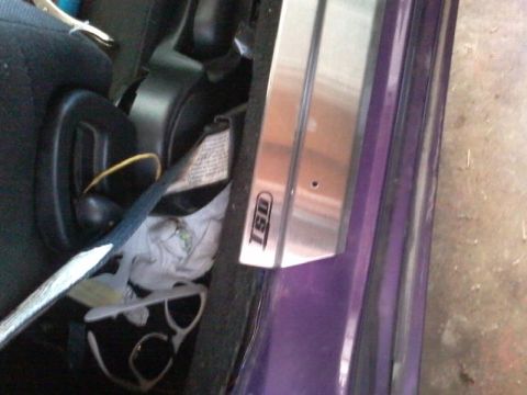 1995 Ford Probe - A close-up view of the interior door sill of a purple 1995 Ford Probe, featuring a brushed metal door sill plate with the 'TSI' logo. The d…