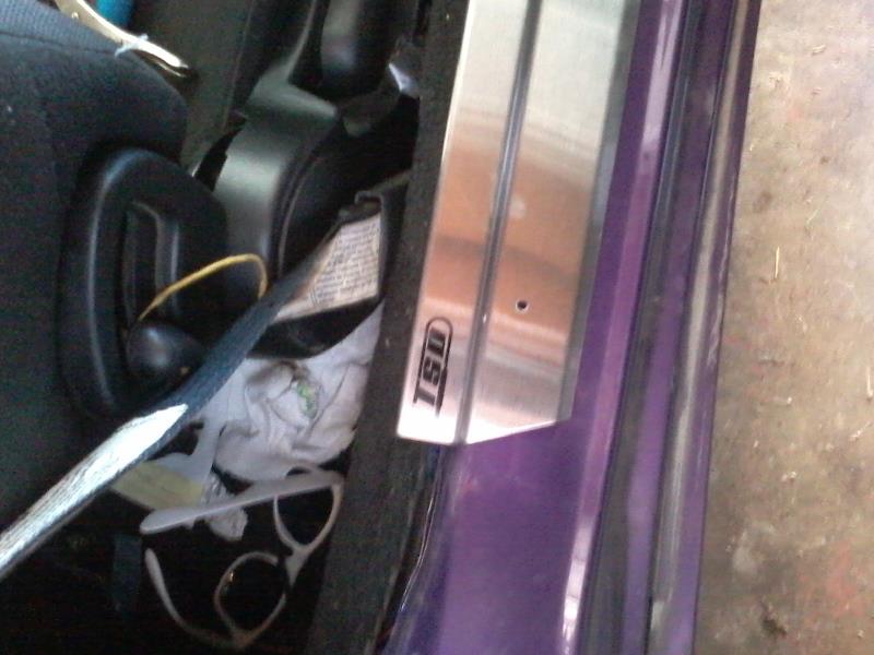 Interior door sill of a purple 1995 Ford Probe with TSI logo.