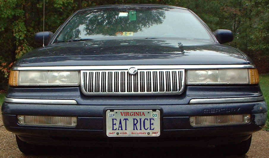 Front of a dark Mercury sedan with chrome waterfall grille and Virginia EAT RICE vanity plate