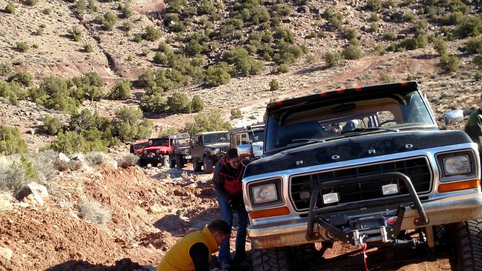 Black Ford Bronco leading a line of off-road vehicles on a rocky trail.
