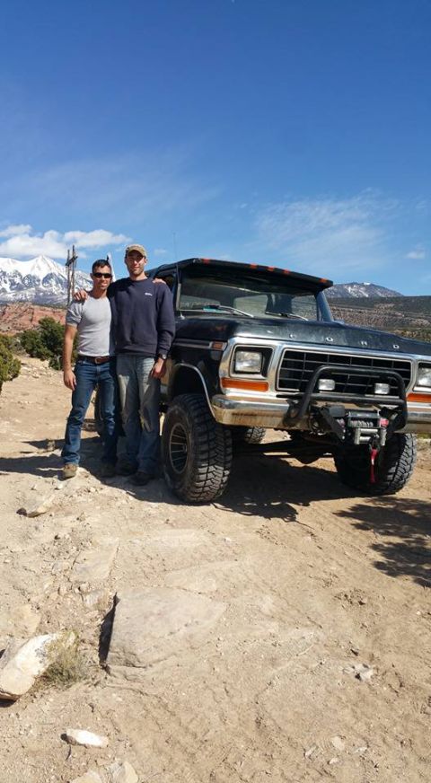 1979 Ford Bronco - Two men stand in front of a black 1979 Ford Bronco on a dirt road with mountains in the background. The Bronco has large off-road tires and…