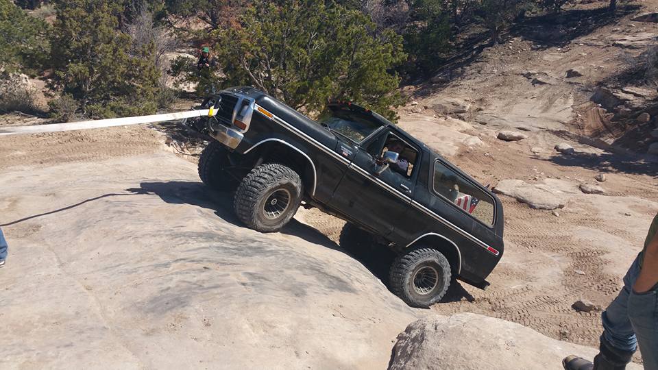 Black 1979 Ford Bronco off-roading on a rocky trail.