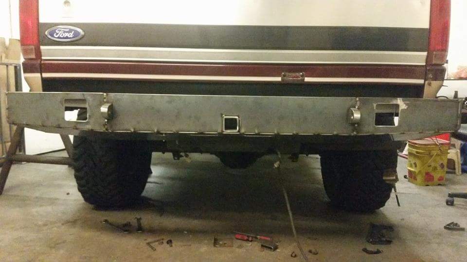 Rear view of a Ford Bronco with a custom metal bumper and hitch receiver.
