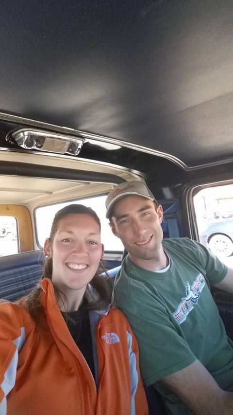 1979 Ford Bronco - A man and a woman smile for a selfie inside the interior of a vehicle. The woman is wearing an orange and blue jacket, and the man is weari…