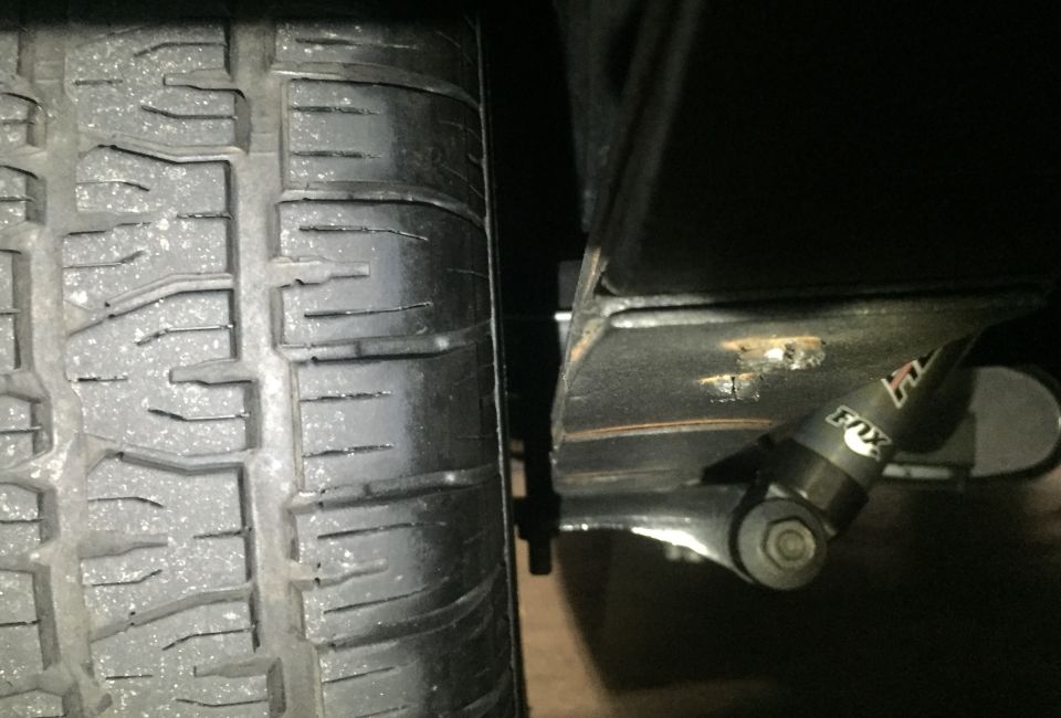 Tire tread next to a FOX shock absorber on a vehicle.