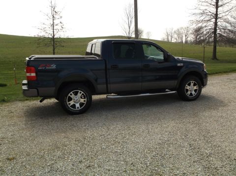 2005 Ford F-150 - Side view of a dark blue 2005 Ford F-150 SuperCrew 4x4 pickup truck with a tonneau cover.