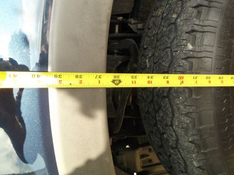 2005 Ford F-150 - A measuring tape is used to measure the wheel well clearance on a vehicle.