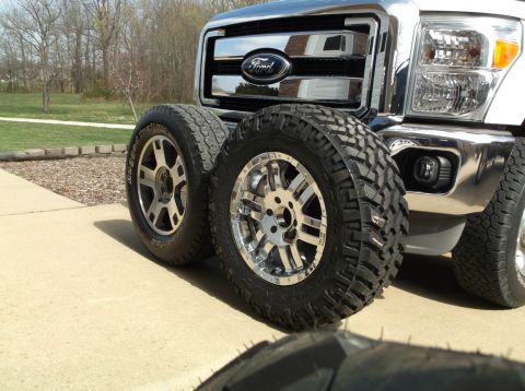 2005 Ford F-150 - Ford truck front end with two aftermarket wheels and tires placed in front.