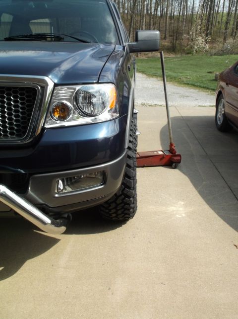 2005 Ford F-150 - Front quarter view of a blue 2005 Ford F-150, showing its large tires and grille detail.