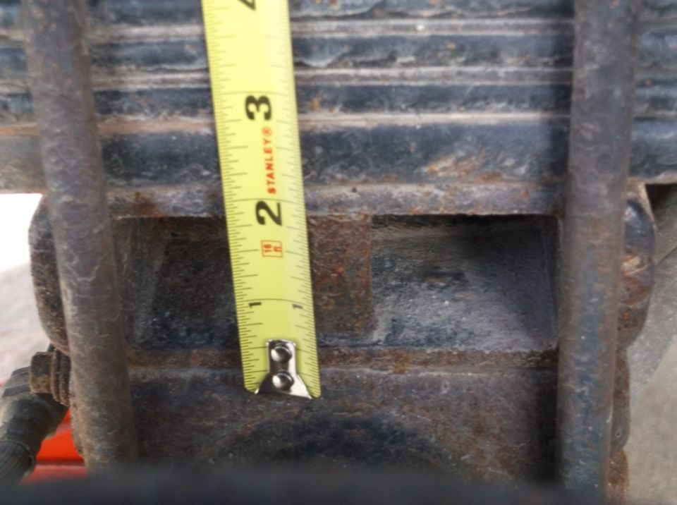 Leaf spring with a yellow Stanley tape measure showing approximately 2.5 inches