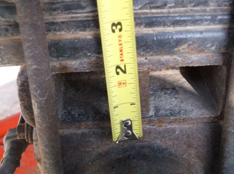 2005 Ford F-150 - A tape measure is used to measure a rusty suspension component on a vehicle.