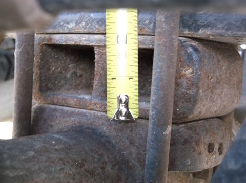 2005 Ford F-150 - A tape measure is used to gauge the height of a rusty vehicle suspension component.