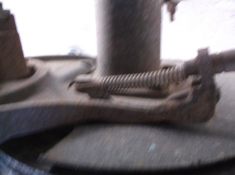 2005 Ford F-150 - Close-up of a rusted brake caliper spring mechanism on a vehicle part.