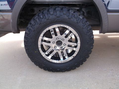 2005 Ford F-150 - A close-up shot focuses on the chrome wheel and tire mounted on a truck.