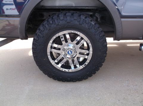 2005 Ford F-150 - A close-up view of a chrome wheel and tire assembly mounted on a vehicle.