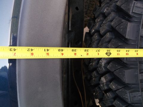 2005 Ford F-150 - Measuring tire clearance with a yellow tape measure against a vehicle's body and tire tread.