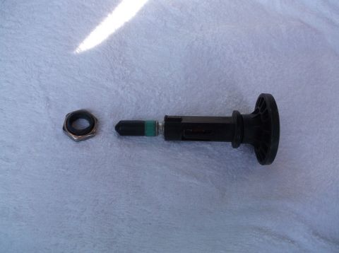 2005 Ford F-150 - A tire pressure sensor and its retaining nut are shown disassembled on a light-colored, textured surface.