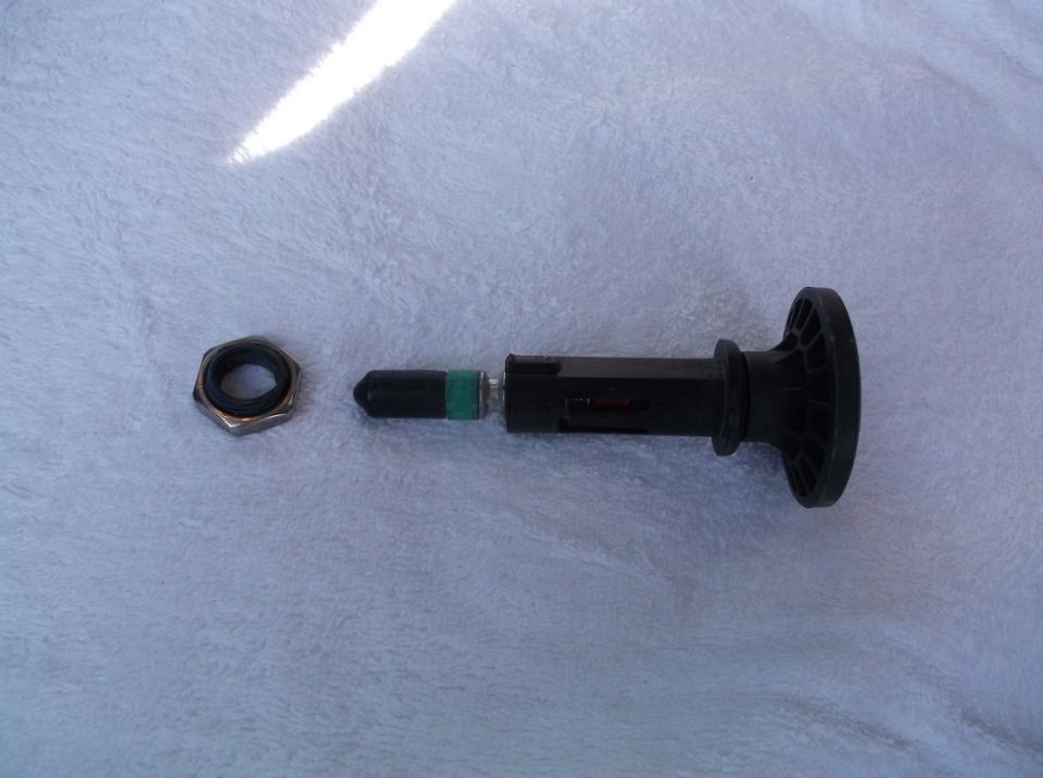 Tire pressure sensor and mounting nut laid out on a textured surface