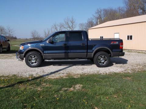 2005 Ford F-150 - Side view of a blue 2005 Ford F-150 FX4 Off Road pickup truck with aftermarket wheels.
