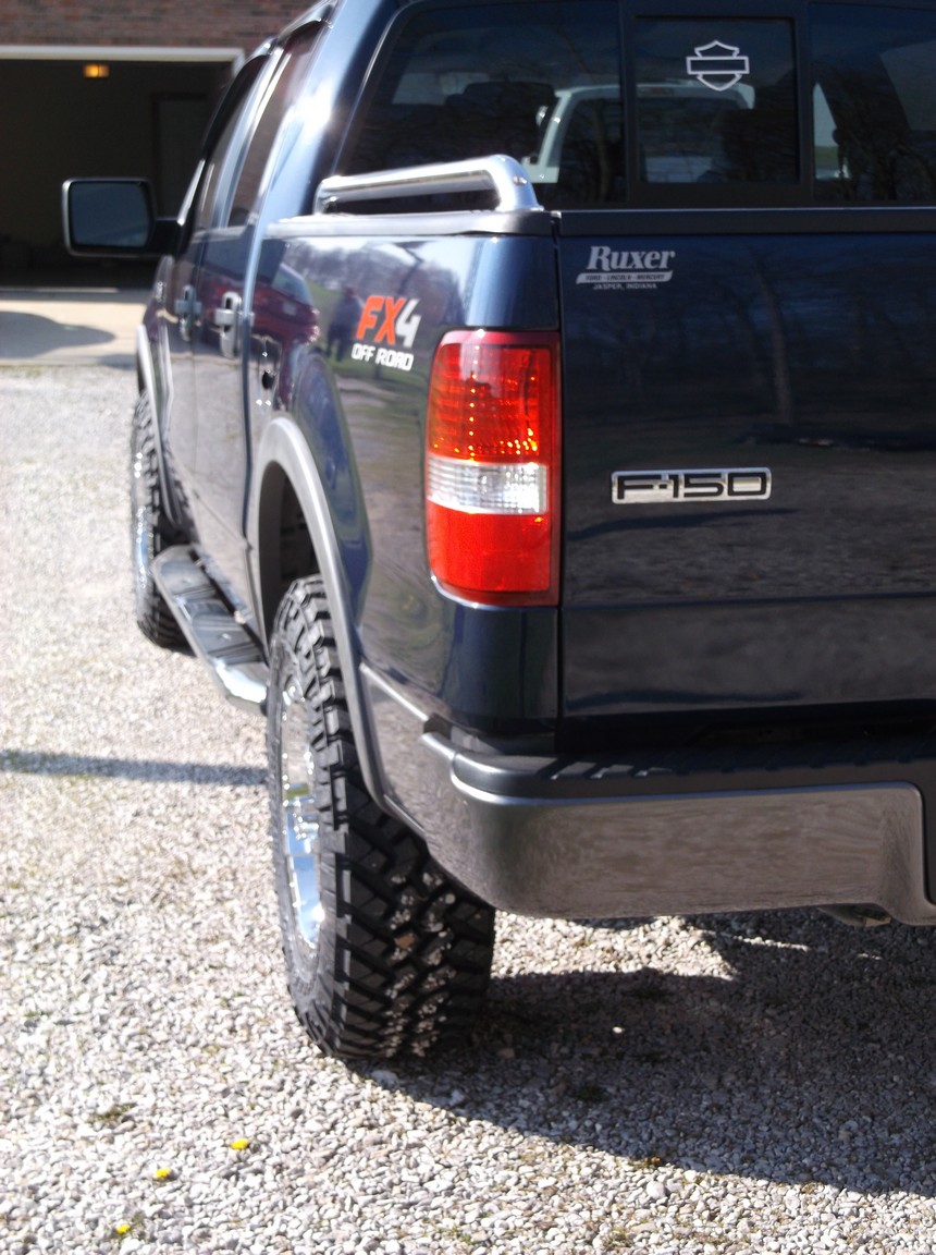 Dark blue Ford F-150 FX4 pickup truck, rear view showing taillight and F-150 badge