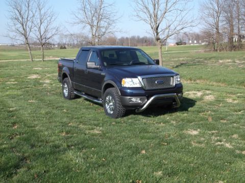 2005 Ford F-150 - This 2005 Ford F-150 pickup truck is shown from a three-quarter front view, parked outdoors on a grassy field.
