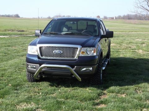2005 Ford F-150 - Front view of a dark blue Ford F-150 truck with a chrome bull bar and aftermarket wheels.