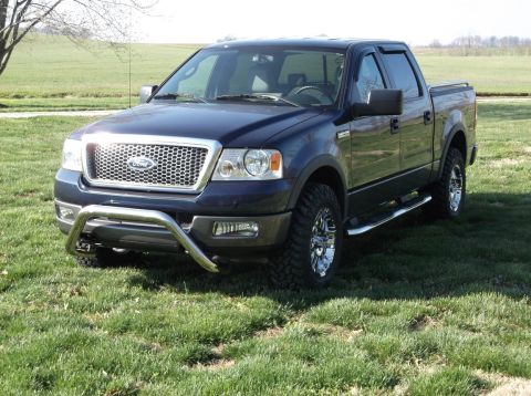 2005 Ford F-150 - This dark blue 2005 Ford F-150 pickup truck is shown in a three-quarter front view, a chrome bull bar and custom wheels.