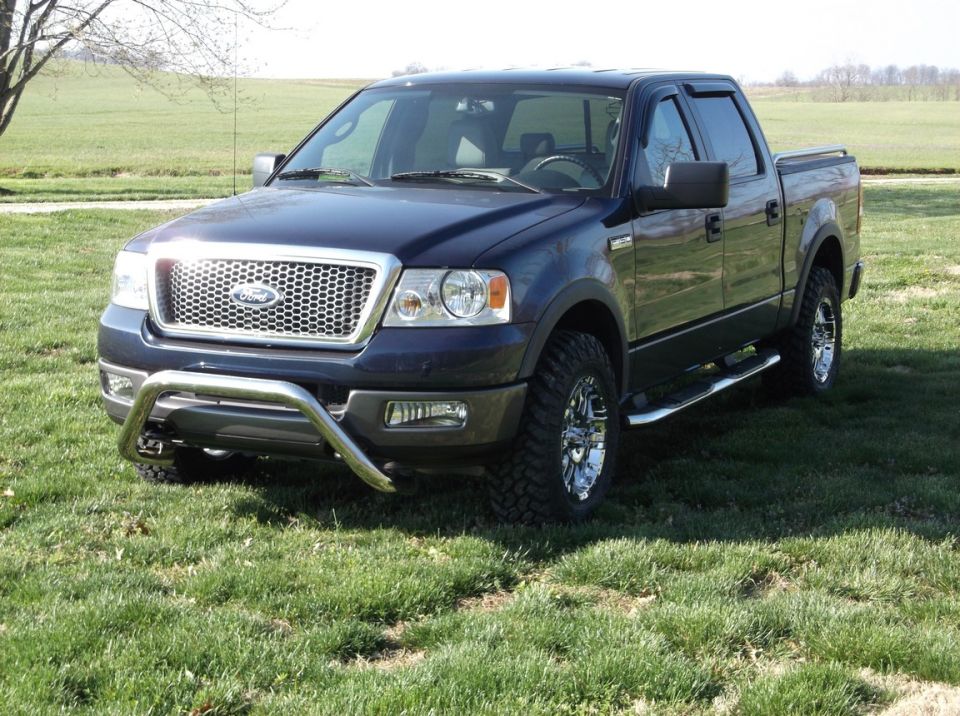 Dark blue 2005 Ford F-150 pickup truck, 3/4 front view, with chrome bull bar and aftermarket wheels