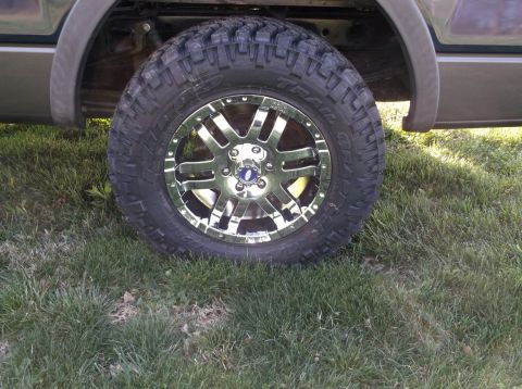 2005 Ford F-150 - Close-up of a chrome wheel and aggressive off-road tire mounted on a truck.
