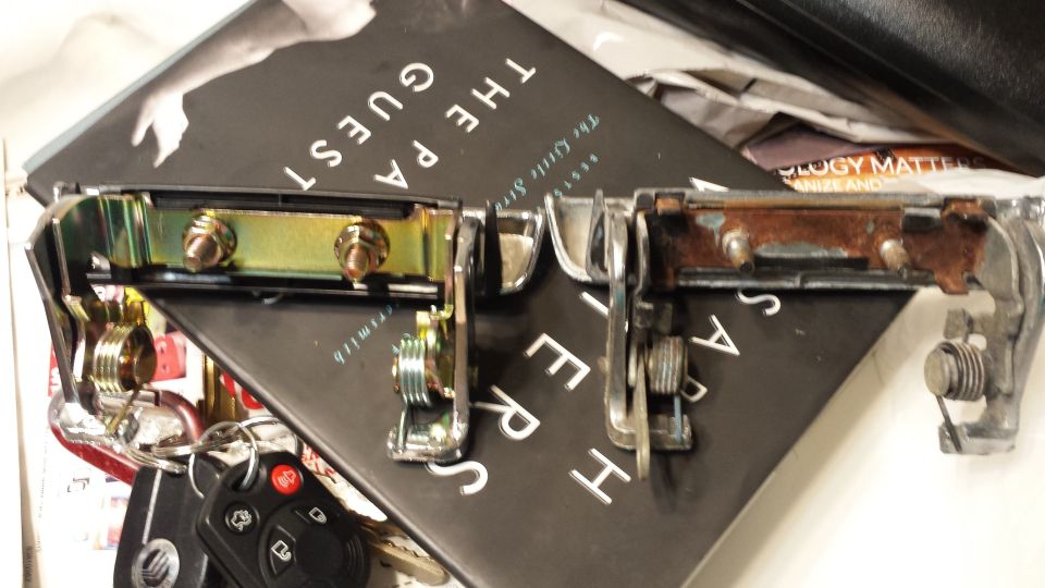 Two car door handles, one looks new, the other is rusty. Keys are on the left