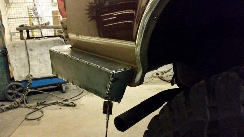 1996 Ford Bronco - A custom metal step bumper is shown, attached to the rear of a vehicle in a workshop setting.