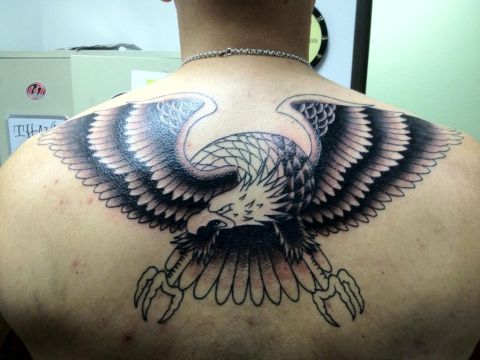 1996 Ford Bronco - A large eagle tattoo with spread wings covers the subject's back.