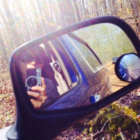 1996 Ford Bronco - Self-portrait in side mirror with another vehicle on a dirt road.