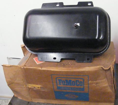 1968 Mercury Cougar - A black metal reservoir part is shown resting on a cardboard box with Ford branding.