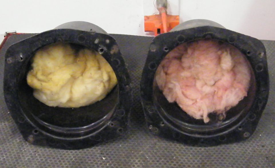 Two speaker enclosures cut open showing yellow and pink fiber stuffing material