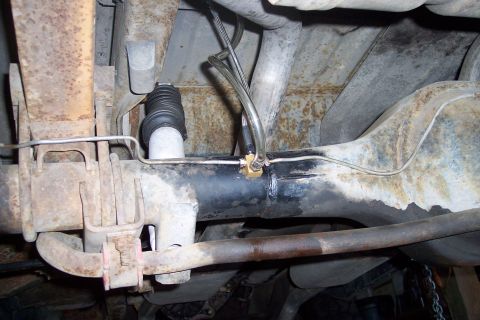1978 Ford Bronco - Close-up view of the undercarriage, focusing on the rear axle and suspension system.