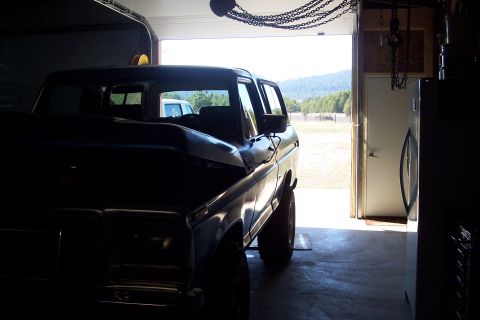 1978 Ford Bronco - 1978 Ford Bronco parked inside a garage with the door open to a sunny outdoor scene.