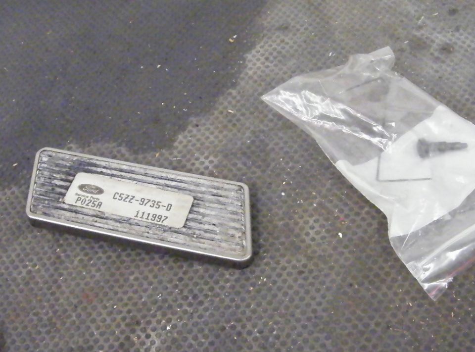 Ford part labeled C52Z-9735-D, P025A, and 111997. Also a plastic bag with hardware