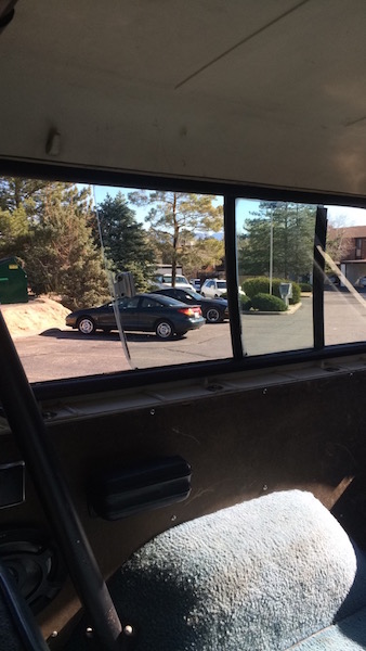 1981 Ford Bronco - View from inside a classic SUV shows a parking lot with other vehicles under a clear sky.