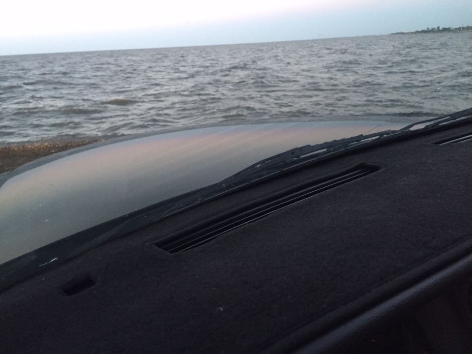 Car dashboard looking out at the ocean