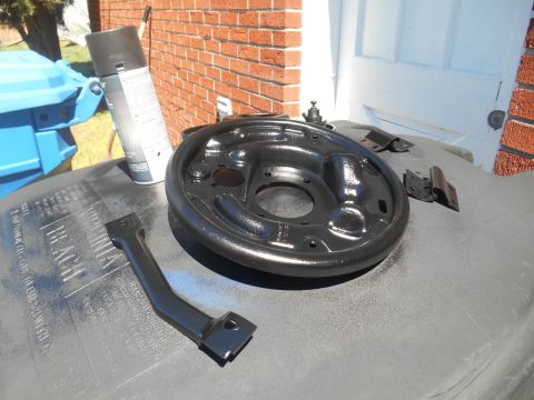 1972 Ford Bronco - Newly painted brake drum and associated hardware sit on a surface, ready for installation.