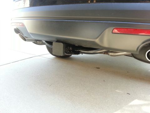 2016 Ford Explorer - The rear of a black SUV is shown, focusing on the bumper, exhaust, and trailer hitch.