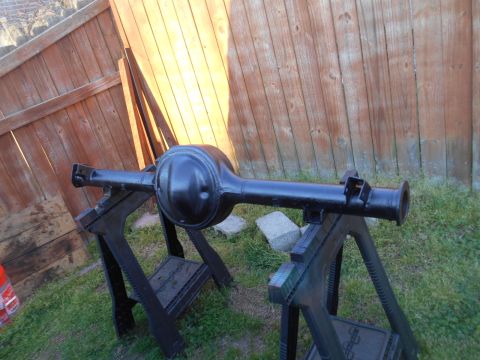 1972 Ford Bronco - A freshly painted rear axle assembly is drying outdoors on sawhorses.