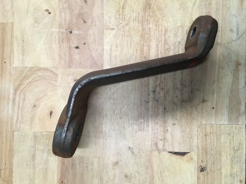 1993 Ford Bronco - A rusty drop pitman arm is shown resting on a wooden workbench.
