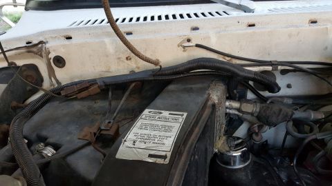 1978 Ford Bronco - The image shows a close-up view of the engine bay of a vehicle, focusing on the firewall and components near the windshield wipers. A "SERV…