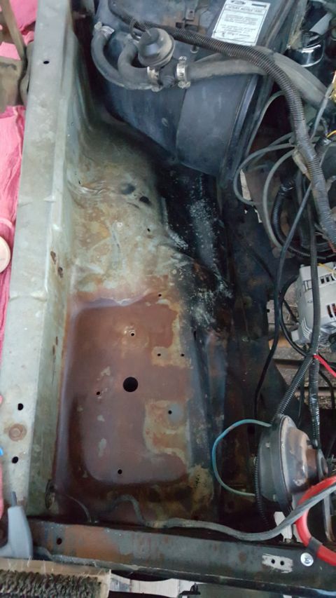 1978 Ford Bronco - This image shows the engine bay of a vehicle, with a focus on the driver's side fender well and inner fender area. The metal shows signific…