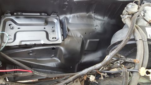 1978 Ford Bronco - This is a close-up view of the engine bay of a 1978 Ford Bronco, showing the battery tray and various engine components. The firewall and s…