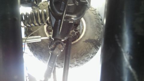 1979 Ford Bronco - This is a low-angle shot of the underside of a vehicle, focusing on the rear axle, suspension components, and a large tire. A shock absorbe…