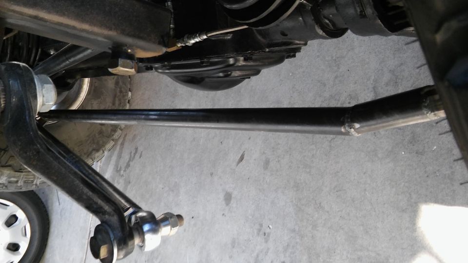 Underside view of vehicle steering linkage, showing tie rod and suspension components.